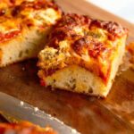 Homemade focaccia pizza with crispy golden crust, melted mozzarella, pepperoni, and dollops of ricotta cheese