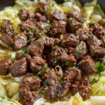 Garlic Butter Steak Bites served with sautéed cabbage and lemon
